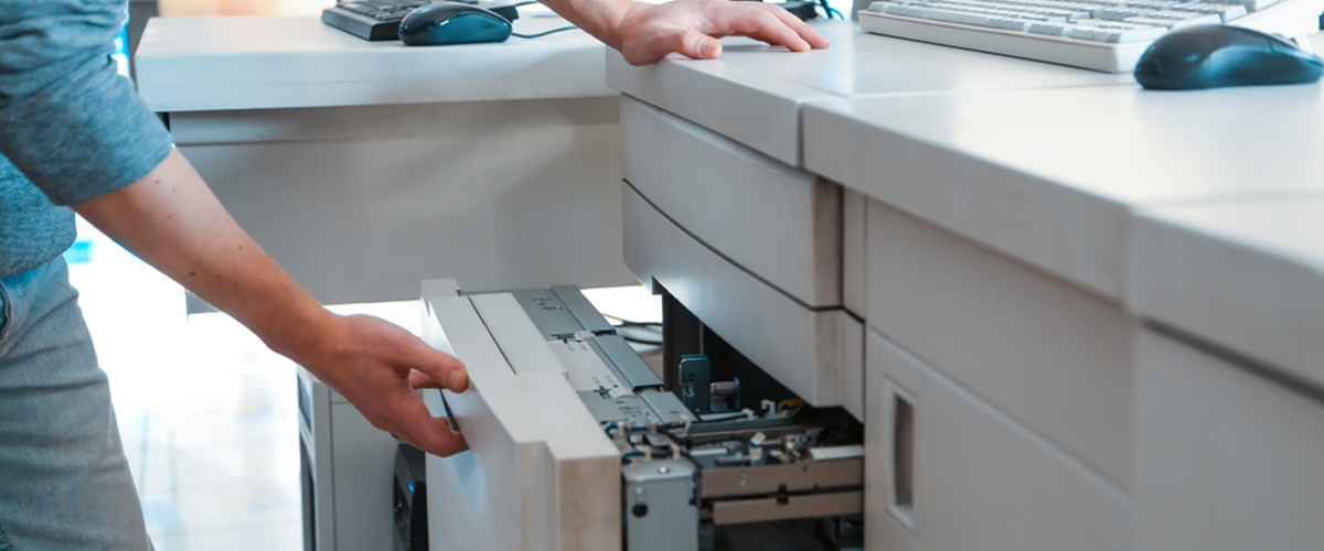 Man clearing paper jam in leased printer in Toronto