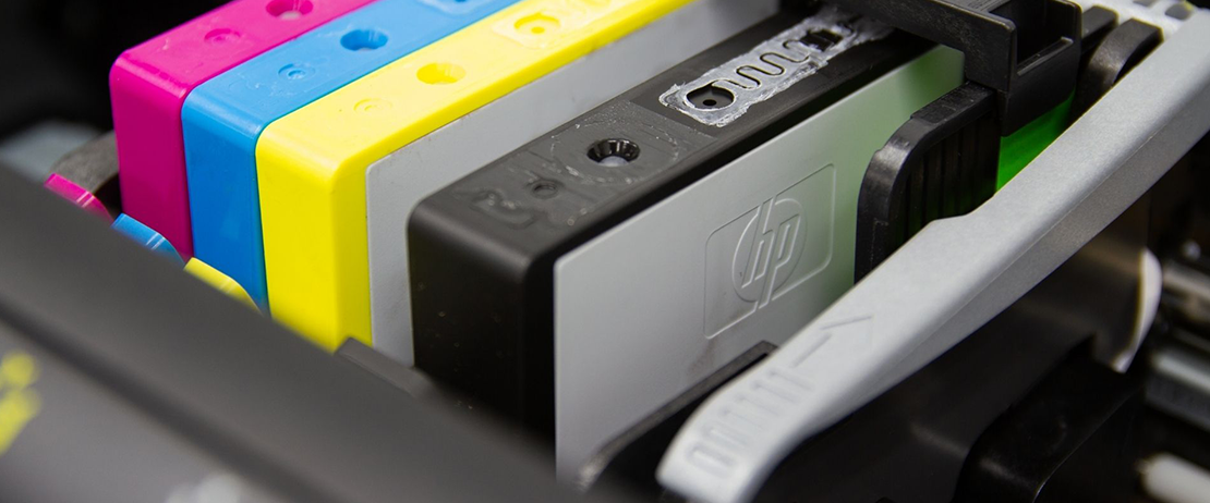 Pink, blue, yellow, and black printer ink cartridges 