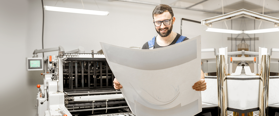 A man smiling at his printed work