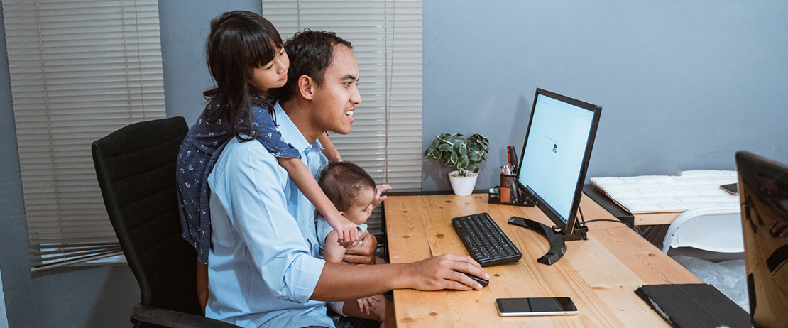 a father working from home with his two children playing in his office
