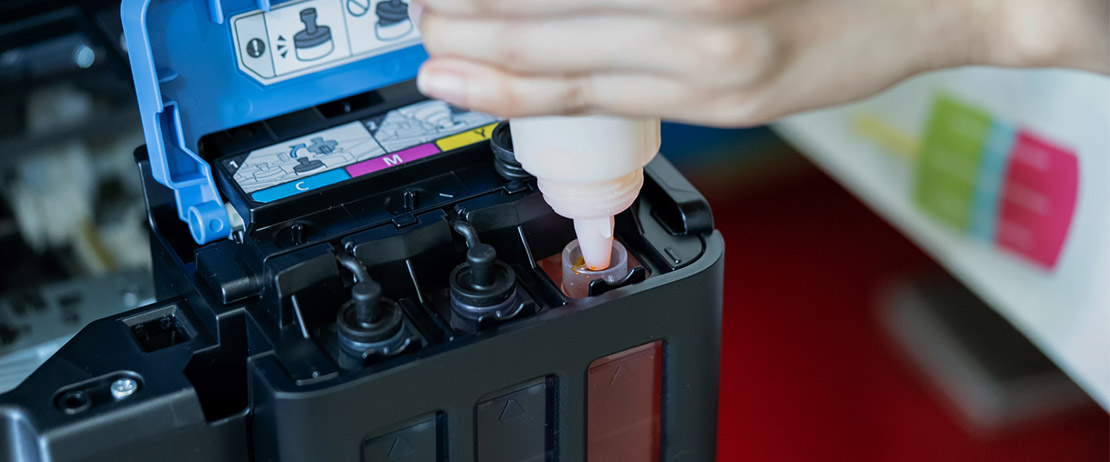 a person refilling ink in an ink tank printer