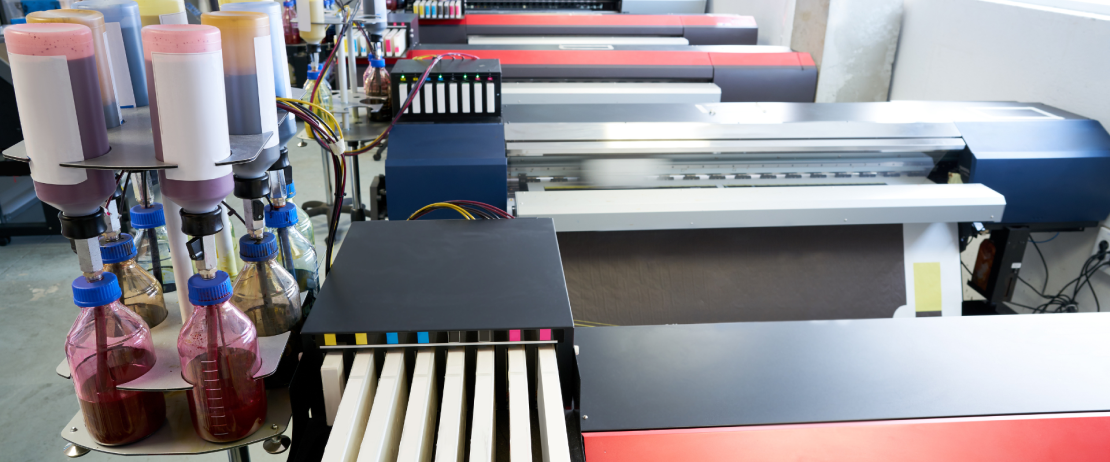 A row of large format printers in an office