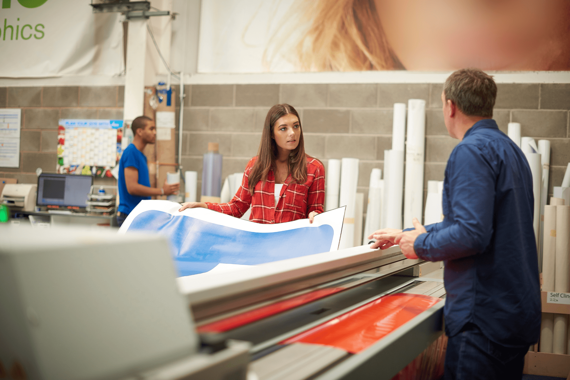 An event planner uses a large-scale printer to print a blue banner