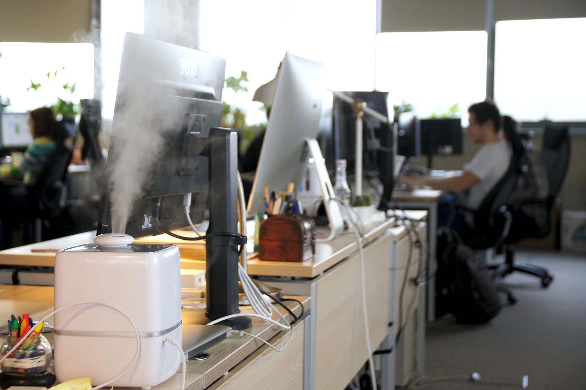 A working humidifier on top of an employee’s desk in an office