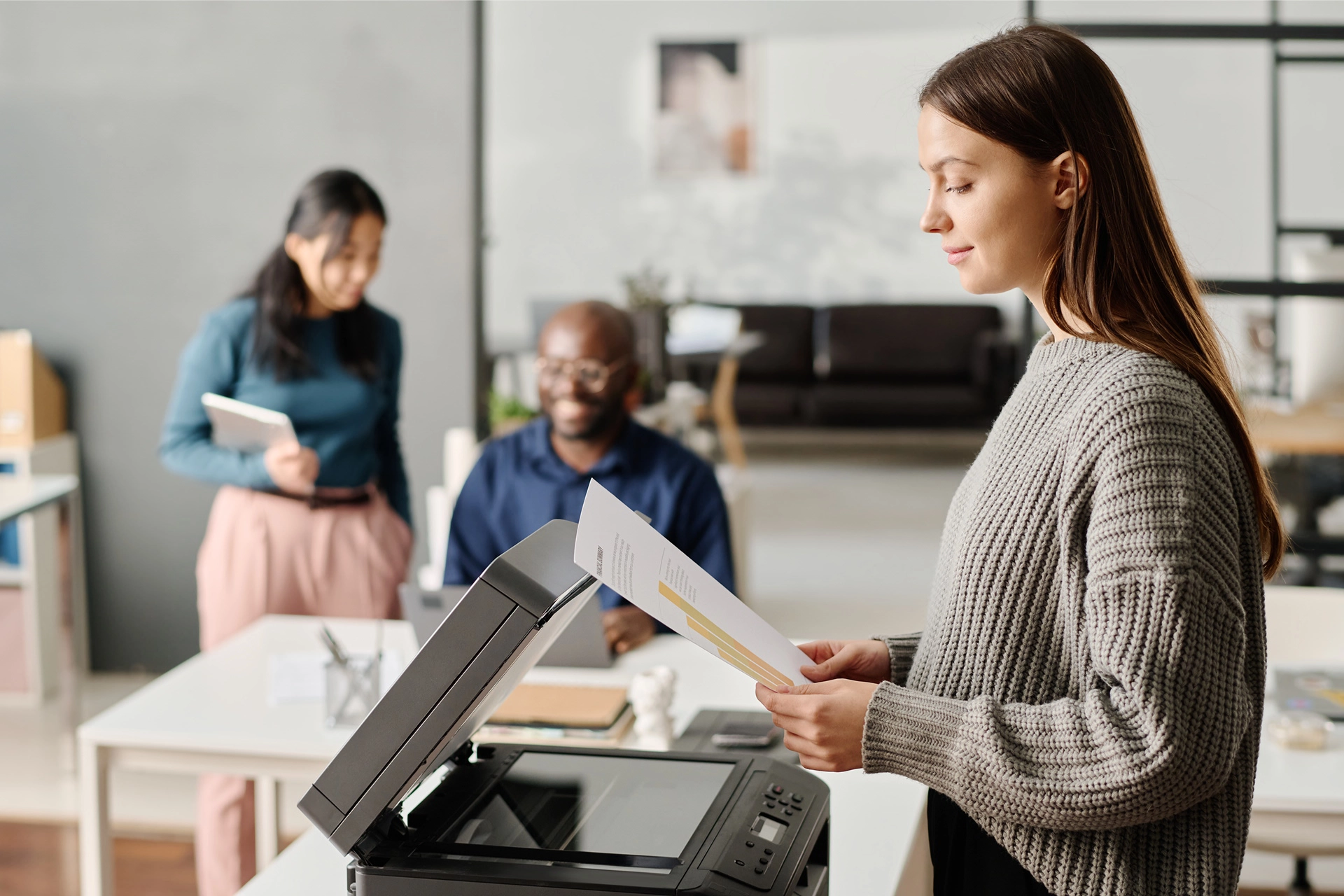 A women at a printer at work.
