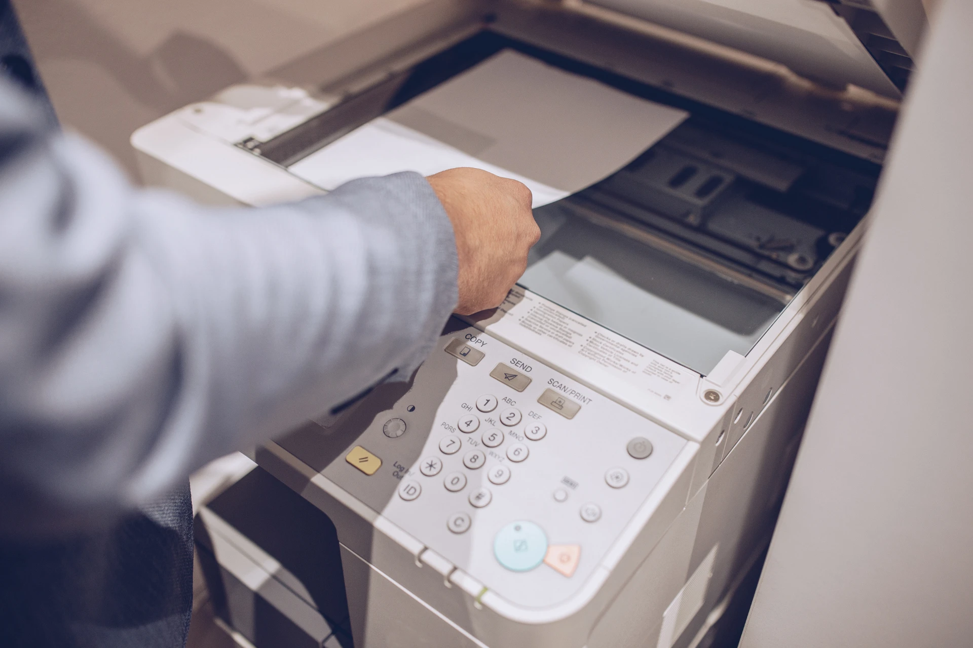 An employee scanning a document on an MFP in an office