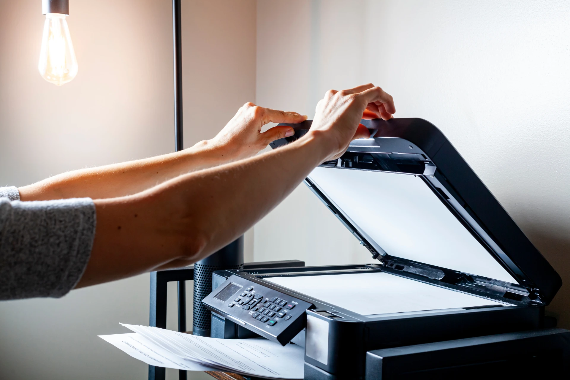 A person scanning a document on a flatbed scanner/printer